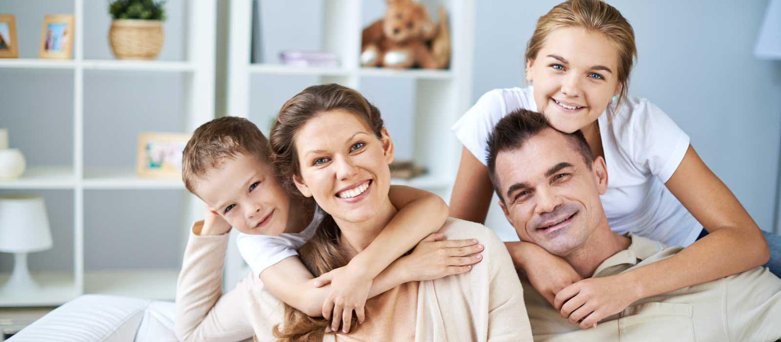 Smiling Bellevue family of four relaxing in their tidy living room, symbolizing trust in Simply Clean's highly rated home cleaning services.