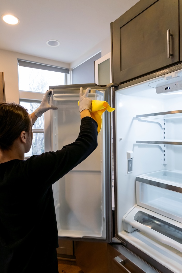 Simply Clean Bellevue home cleaning professional cleaning a refrigerator interior