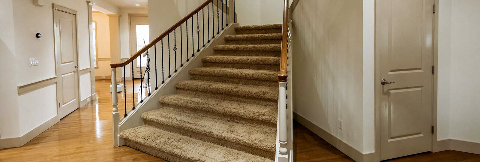 Empty foyer with staircase and hardwood floors in a Seattle home before move-in cleaning by Simply Clean