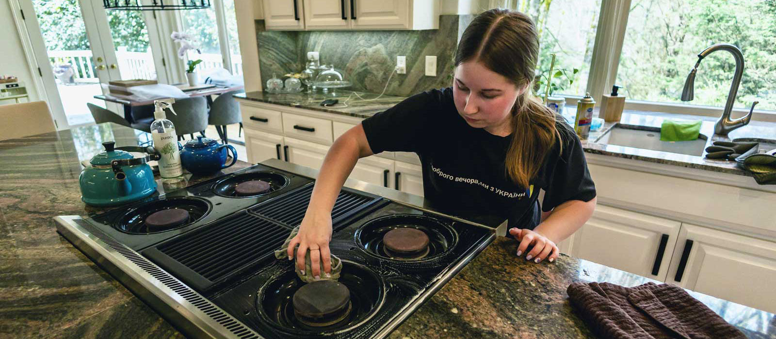 Professional Seattle house cleaner performing detailed kitchen cleaning service, demonstrating the quality work included in Simply Clean's transparent pricing for deep cleaning, move-out cleaning, and recurring maintenance services.