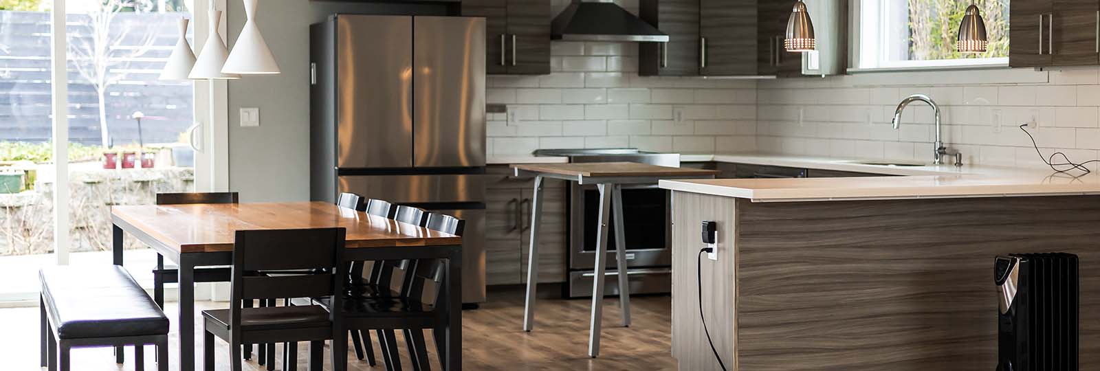 Clean open-plan kitchen and dining area in a Seattle home after move-out cleaning by Simply Clean — hardwood floors, stainless appliances, and empty countertops ready for final walkthrough