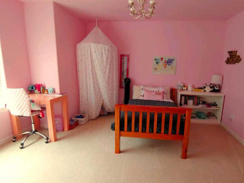 Clean and organized girl's bedroom with vacuumed floors, tidy craft table, bed, and castle tent after professional cleaning in Bellevue.