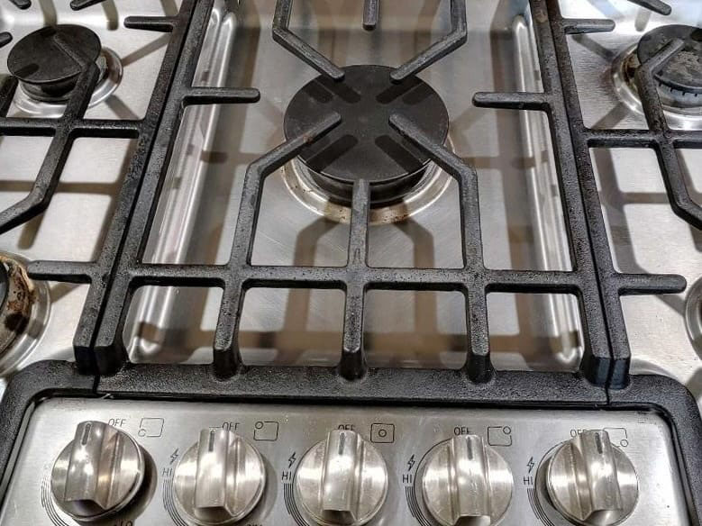 Clean and shiny Bosch stainless steel 5-burner gas stove with a polished Dacor downdraft hood after professional deep kitchen cleaning in Bellevue.