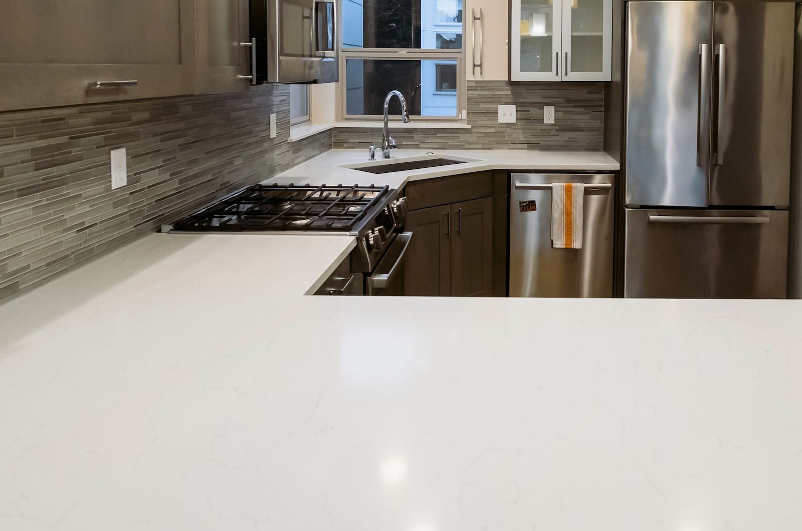 After image of a Ballard Seattle townhouse kitchen with polished engineered stone countertops and cleaned cabinets following a professional move-out cleaning.