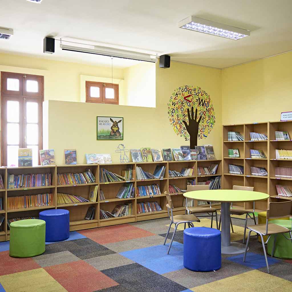 Clean and organized preschool learning space in Seattle with colorful chairs, open floors, and neatly arranged books and art materials
