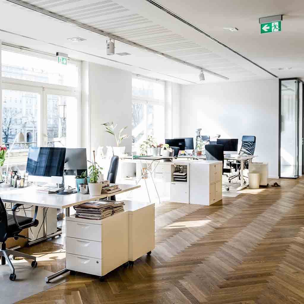 Modern open-plan technology office with shared desks, meeting areas, and organized workstations in Seattle