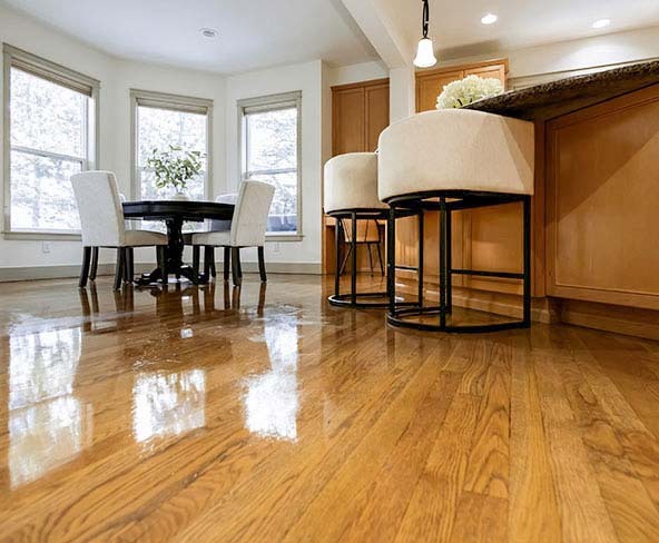 Polished hardwood floors reflecting light in a Seattle kitchen and dining area after move-in cleaning by Simply Clean