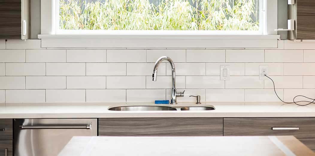 Close-up of a polished kitchen sink and backsplash after professional move-out cleaning in Seattle by Simply Clean