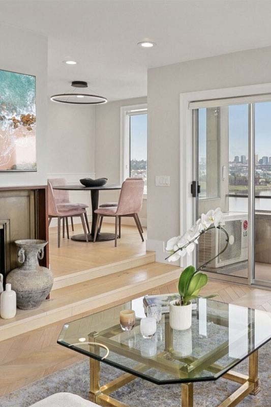 Newly renovated Seattle living room with waterfront view, fireplace, and hardwood floors after post-remodel cleaning by Simply Clean