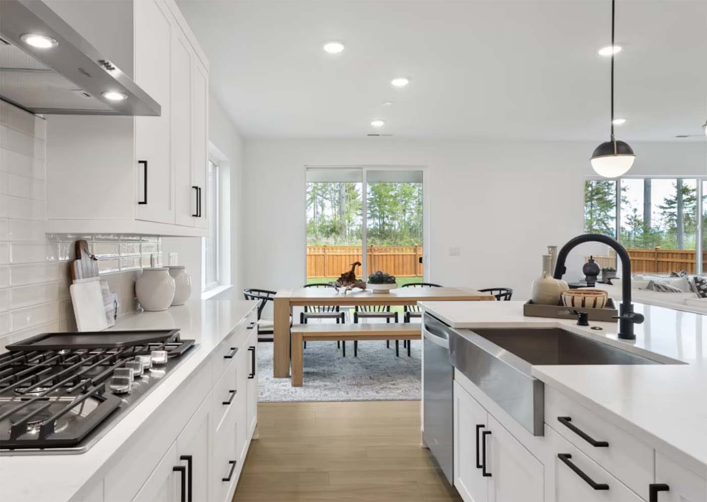 Clean white kitchen with hardwood floors and stainless steel sink in a Seattle home — Simply Clean regular house cleaning service